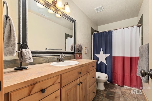 23 Waterline Ln, Cascade, ID 83611 - bathroom with vanity, a textured ceiling, a textured wall, stone finish flooring, and a shower with shower curtain
