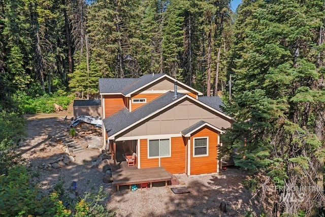 23 Waterline Ln, Cascade, ID 83611 - view of front of home with a wooded view, board and batten siding, a wooden deck, and a shingled roof