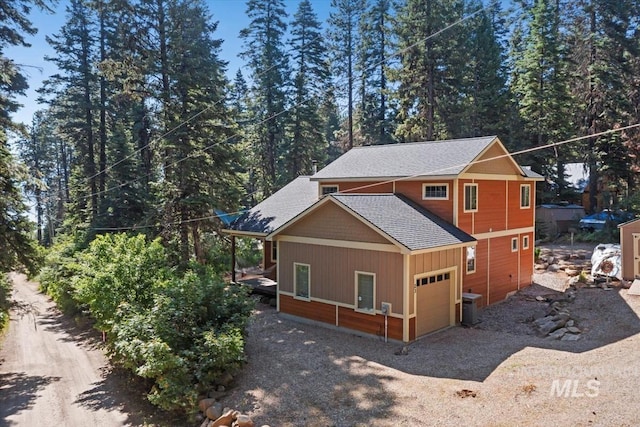 23 Waterline Ln, Cascade, ID 83611 - view of side of home featuring driveway, a shingled roof, and an attached garage