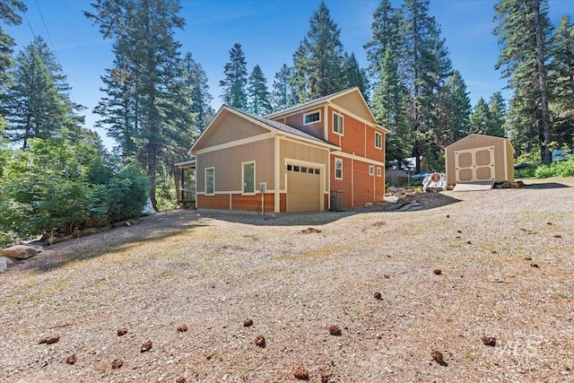 23 Waterline Ln, Cascade, ID 83611 - view of side of home with a garage, a storage unit, and board and batten siding