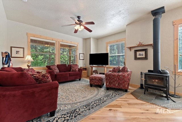 23 Waterline Ln, Cascade, ID 83611 - living area with a wood stove, wood finished floors, a textured ceiling, and ceiling fan