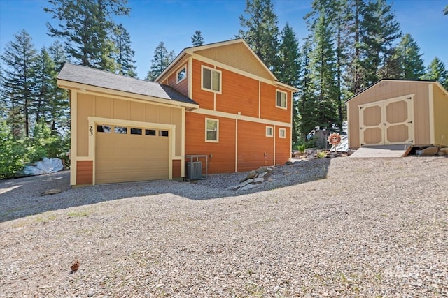 23 Waterline Ln, Cascade, ID 83611 - view of side of property with a storage shed, a garage, board and batten siding, and gravel driveway