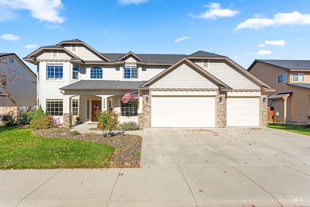 view of front of home featuring a garage, driveway, a front lawn, and stone siding