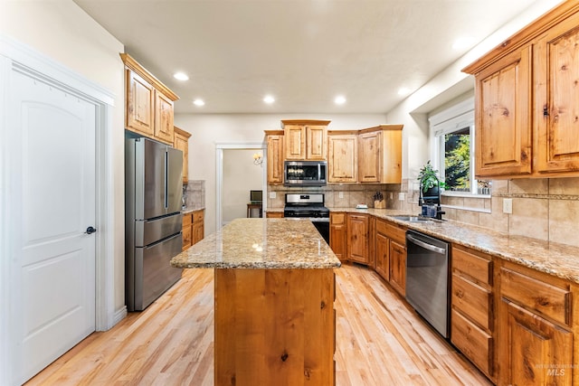 kitchen featuring stainless steel appliances, a center island, a sink, and tasteful backsplash