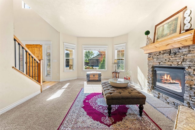 sitting room with baseboards, stairway, a stone fireplace, a textured ceiling, and carpet flooring