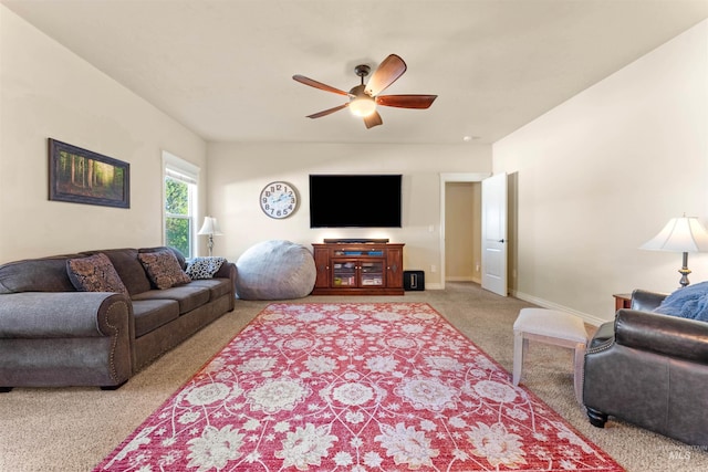 living area featuring baseboards, a ceiling fan, and carpet flooring