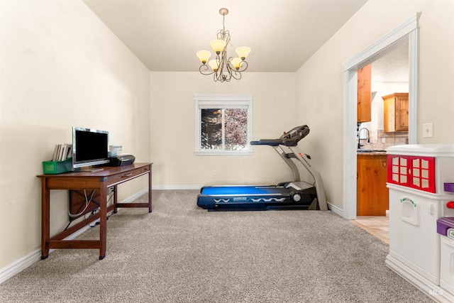 exercise room with baseboards, a notable chandelier, and light colored carpet