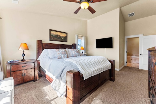 bedroom with light carpet, visible vents, ceiling fan, ensuite bathroom, and vaulted ceiling