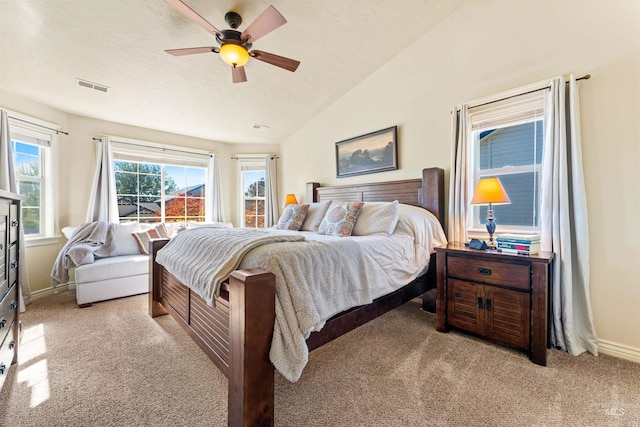 bedroom featuring light carpet, baseboards, visible vents, lofted ceiling, and ceiling fan