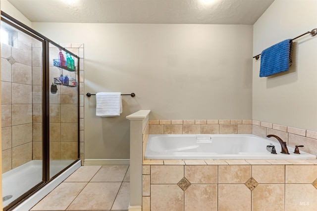 bathroom with a textured ceiling, a stall shower, a garden tub, and tile patterned floors