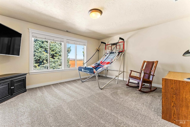 interior space featuring carpet floors, visible vents, a textured ceiling, and baseboards