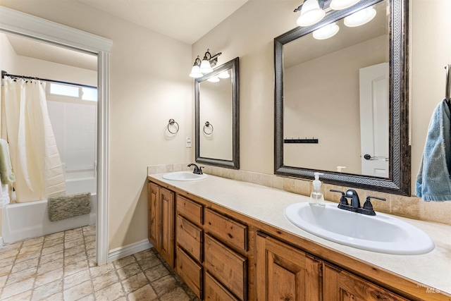 bathroom with shower / bath combo with shower curtain, a sink, baseboards, and double vanity