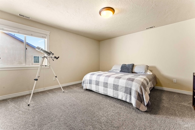 bedroom featuring carpet floors, baseboards, visible vents, and a textured ceiling