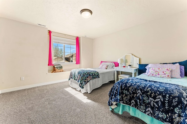 bedroom with a textured ceiling, carpet floors, visible vents, and baseboards