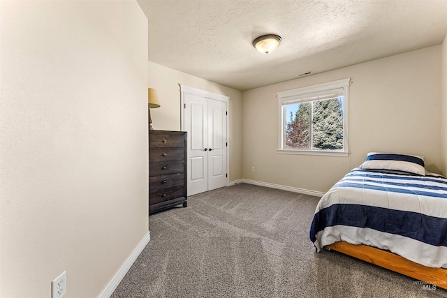 bedroom featuring carpet floors, visible vents, a textured ceiling, and baseboards