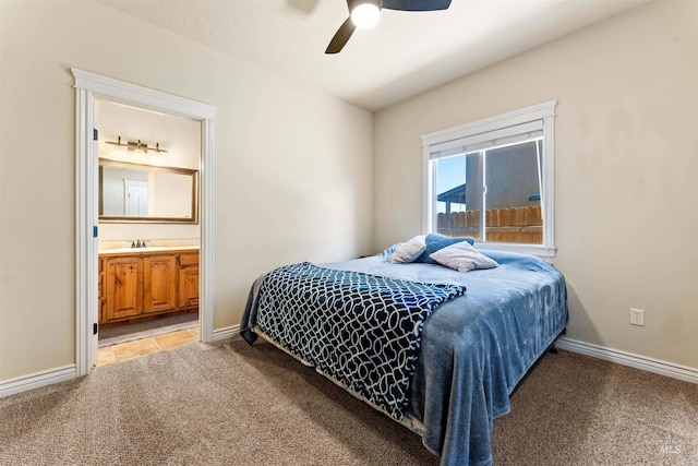 bedroom featuring light carpet, a sink, ensuite bath, and baseboards