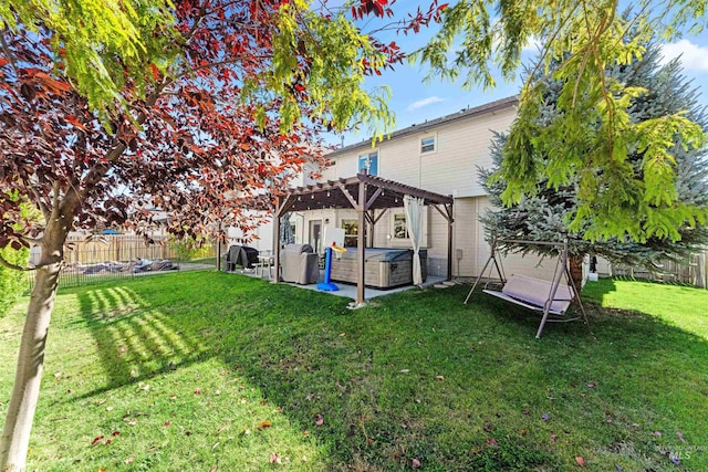 rear view of house featuring a hot tub, a fenced backyard, a lawn, and a pergola