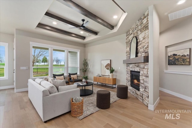 11966 W Zamalek Ct, Kuna, ID 83634 - living area featuring a fireplace, a ceiling fan, wood finished floors, and beamed ceiling