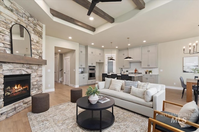 11966 W Zamalek Ct, Kuna, ID 83634 - living room featuring light wood-style floors, recessed lighting, a fireplace, beamed ceiling, and a chandelier