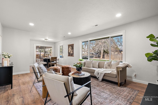 living area featuring plenty of natural light, wood finished floors, recessed lighting, and baseboards
