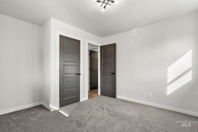 unfurnished bedroom with carpet flooring and baseboards