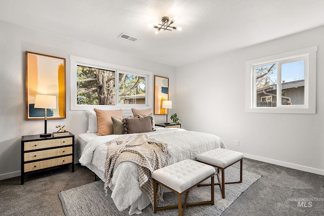 bedroom with dark carpet and baseboards