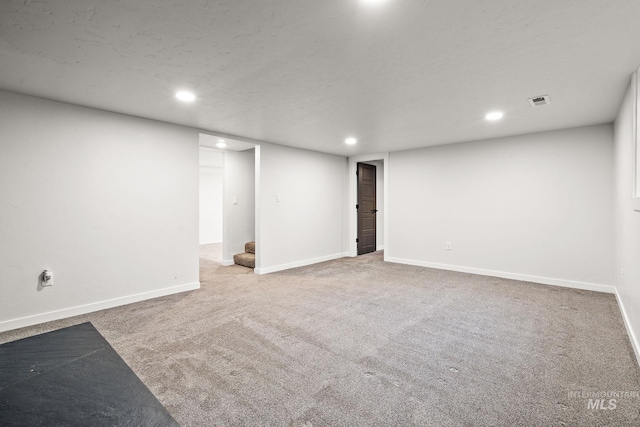 finished basement featuring carpet, recessed lighting, stairs, and baseboards