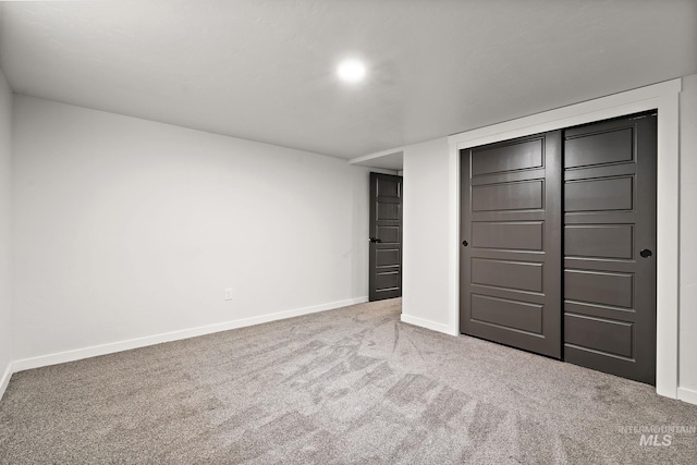 unfurnished bedroom with carpet floors, baseboards, and a closet