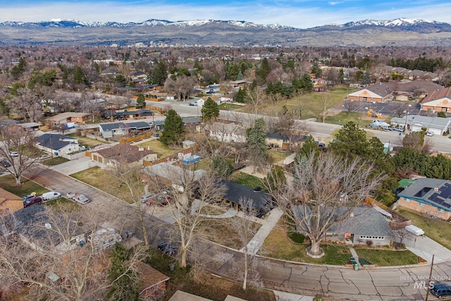 aerial view of property and surrounding area featuring a mountainous background and nearby suburban area