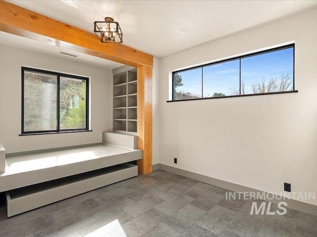 unfurnished bedroom featuring baseboards and a notable chandelier