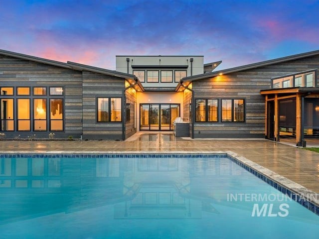 back of property featuring an outdoor pool and a patio area