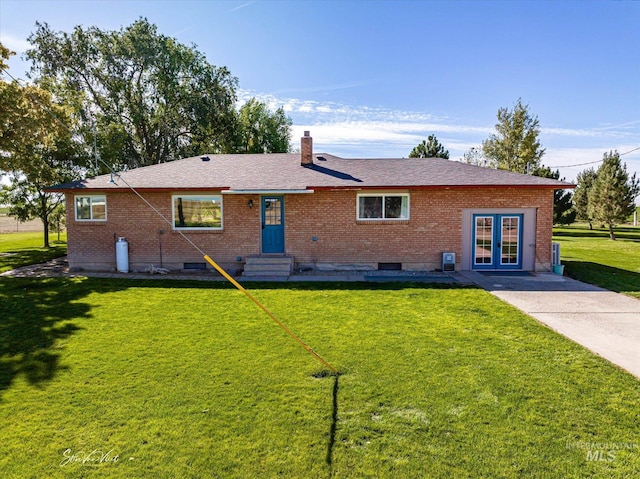 view of front of home with a front yard and french doors