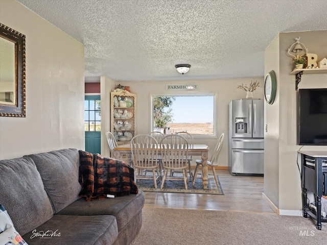 dining room featuring a textured ceiling and light wood-type flooring