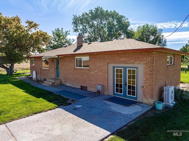 rear view of house with a patio, ac unit, a lawn, and french doors