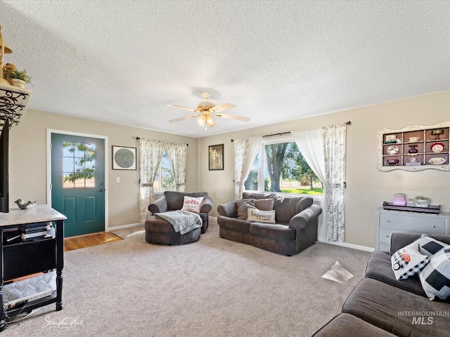 living room with light carpet, a textured ceiling, and ceiling fan