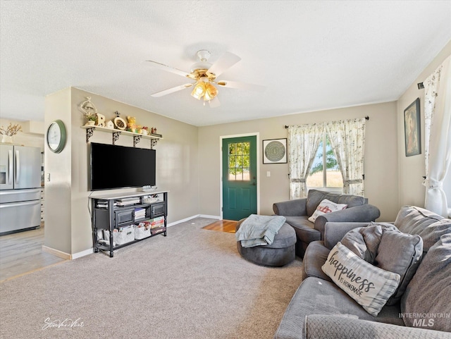 living room featuring carpet floors, a textured ceiling, and ceiling fan