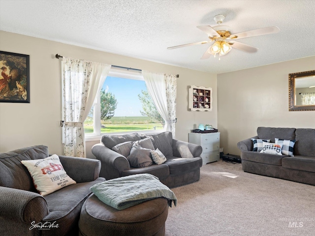 living room with light carpet, ceiling fan, and a textured ceiling