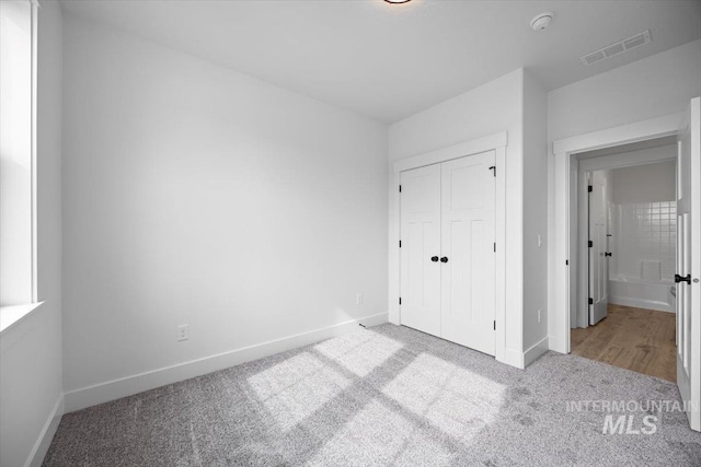 unfurnished bedroom featuring carpet flooring, baseboards, and a closet