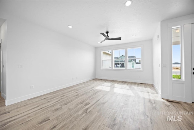 unfurnished living room with light wood finished floors, a ceiling fan, baseboards, and recessed lighting