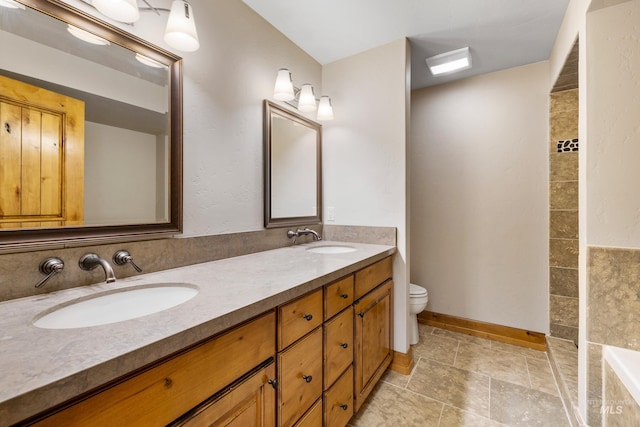 bathroom featuring tile patterned flooring, toilet, and dual bowl vanity