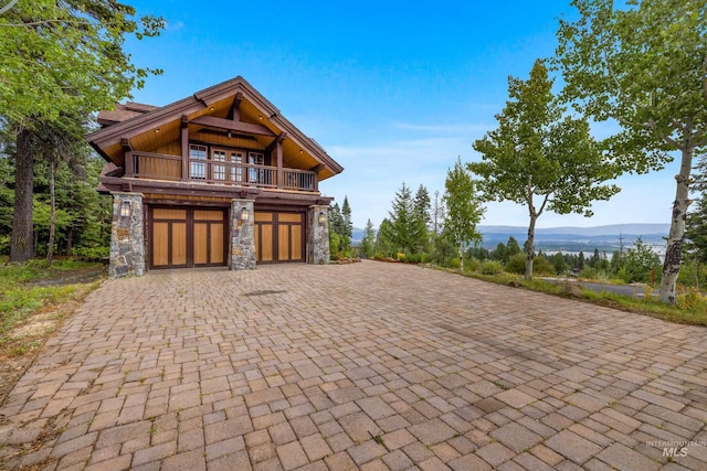 view of front facade featuring a balcony, a garage, and a mountain view