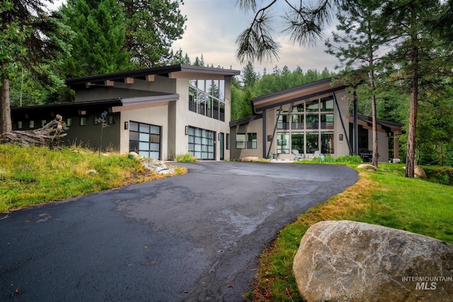 1115 Heavens Gate Ct, Mccall, ID 83638 - modern home with asphalt driveway, stucco siding, and a garage