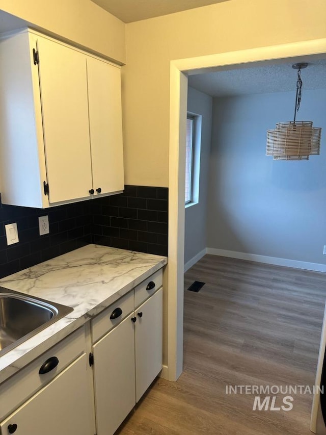 3109 N Tamarack Dr, Boise, ID 83703 - kitchen featuring tasteful backsplash, baseboards, white cabinetry, and light wood-style floors