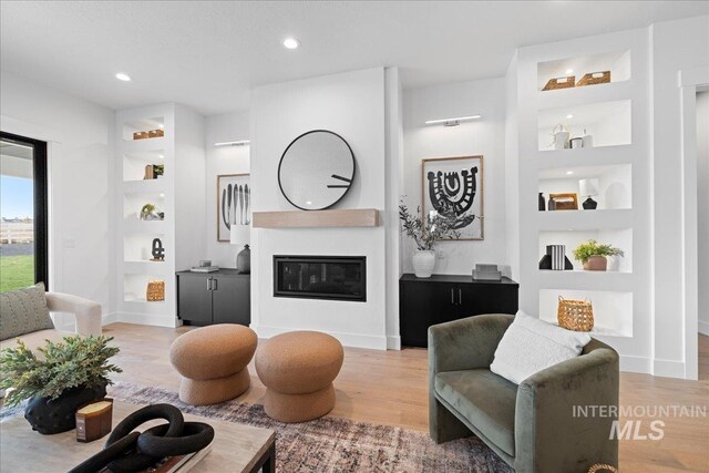 13625 Hickory Rnch, Nampa, ID 83651 - living area featuring light wood-type flooring, built in shelves, a glass covered fireplace, and recessed lighting