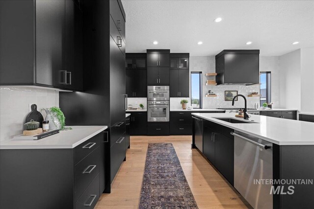 13625 Hickory Rnch, Nampa, ID 83651 - kitchen featuring dark cabinetry, appliances with stainless steel finishes, a sink, tasteful backsplash, and recessed lighting