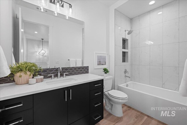 13625 Hickory Rnch, Nampa, ID 83651 - full bath with wood finished floors, toilet, vanity, tub / shower combination, and backsplash