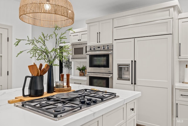 3031 Champagne Ct, Eagle, ID 83616 - kitchen with light stone countertops, built in appliances, white cabinetry, and a notable chandelier