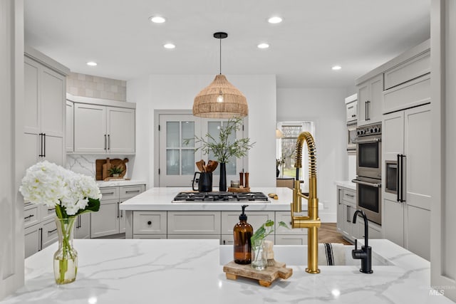 3031 Champagne Ct, Eagle, ID 83616 - kitchen featuring stainless steel appliances, pendant lighting, a kitchen island, light stone counters, and recessed lighting