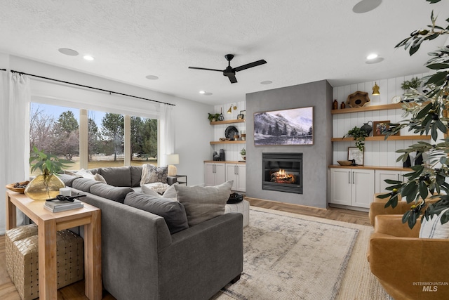 3031 Champagne Ct, Eagle, ID 83616 - living area featuring a ceiling fan, a glass covered fireplace, recessed lighting, and a textured ceiling