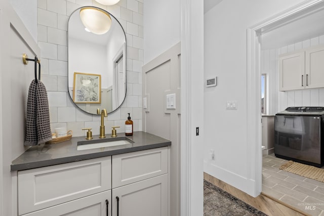 3031 Champagne Ct, Eagle, ID 83616 - interior space with wood finished floors, a sink, baseboards, tasteful backsplash, and washer / clothes dryer